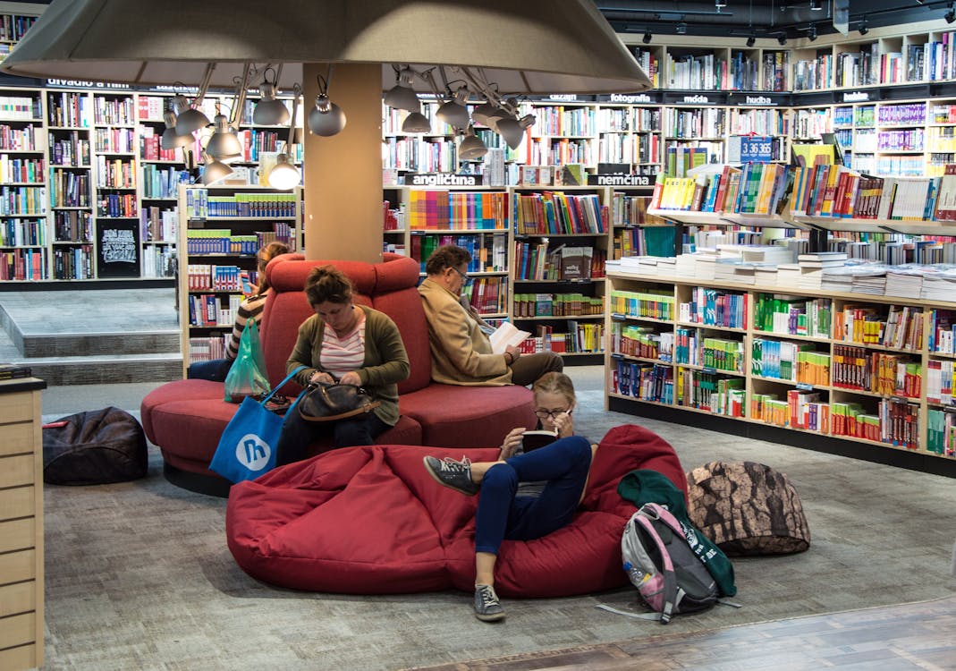 Library patron's reading on comfy chairs while reading new books